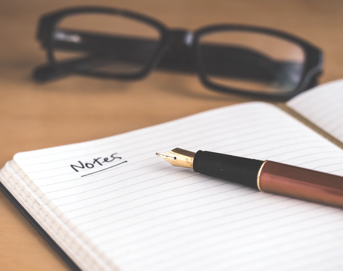 Notebook, fountain pen, and glasses ready for planning